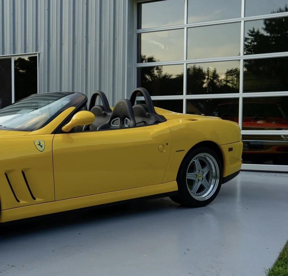 Yellow Ferrari 550 Barchetta outside the AUTOGALERIE shop.